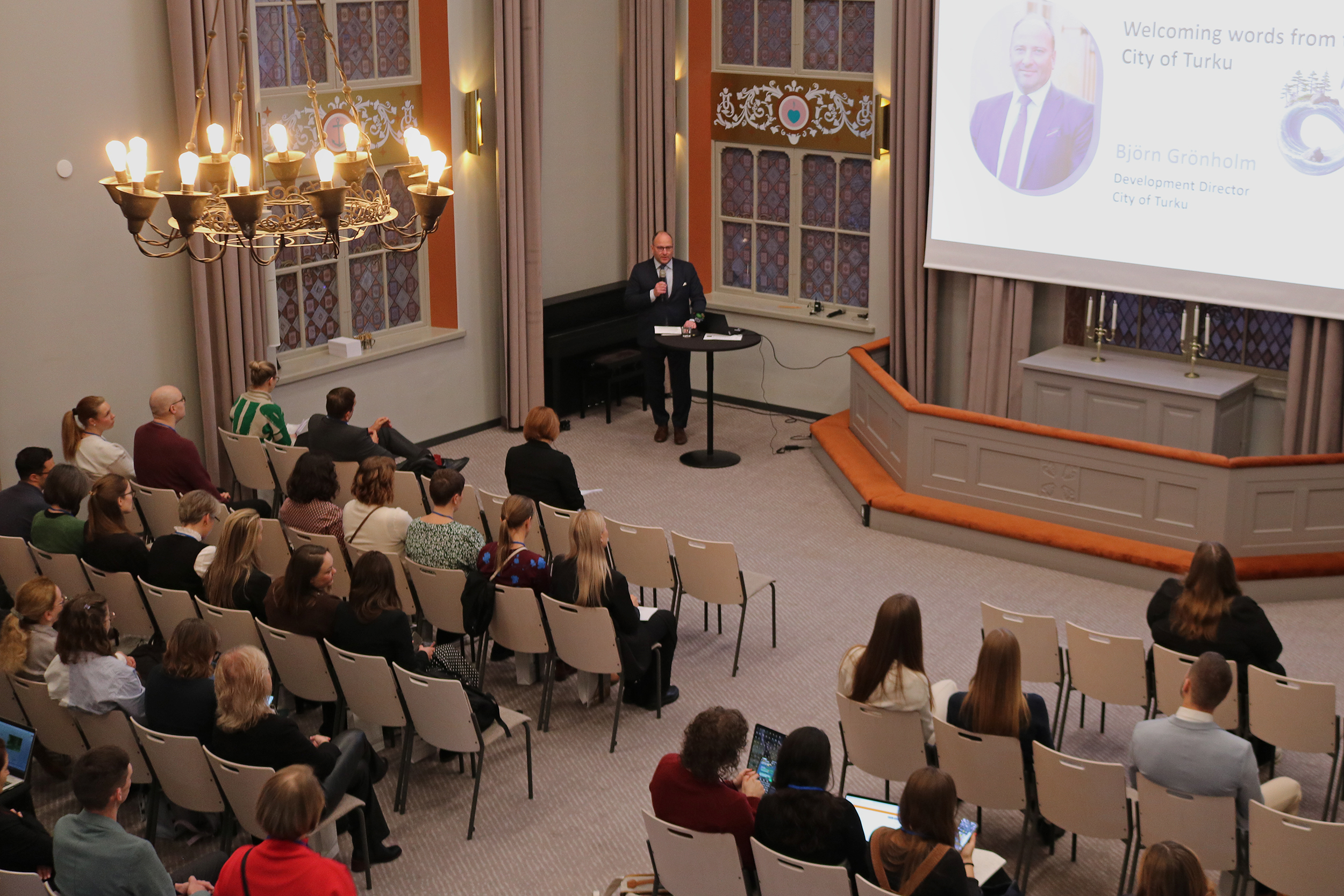 Conference participants listening to the presentation from Turku