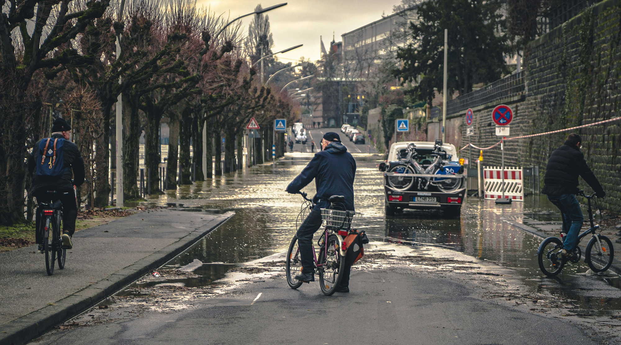 Cyclists are stopped as the road is blocked with the flooding