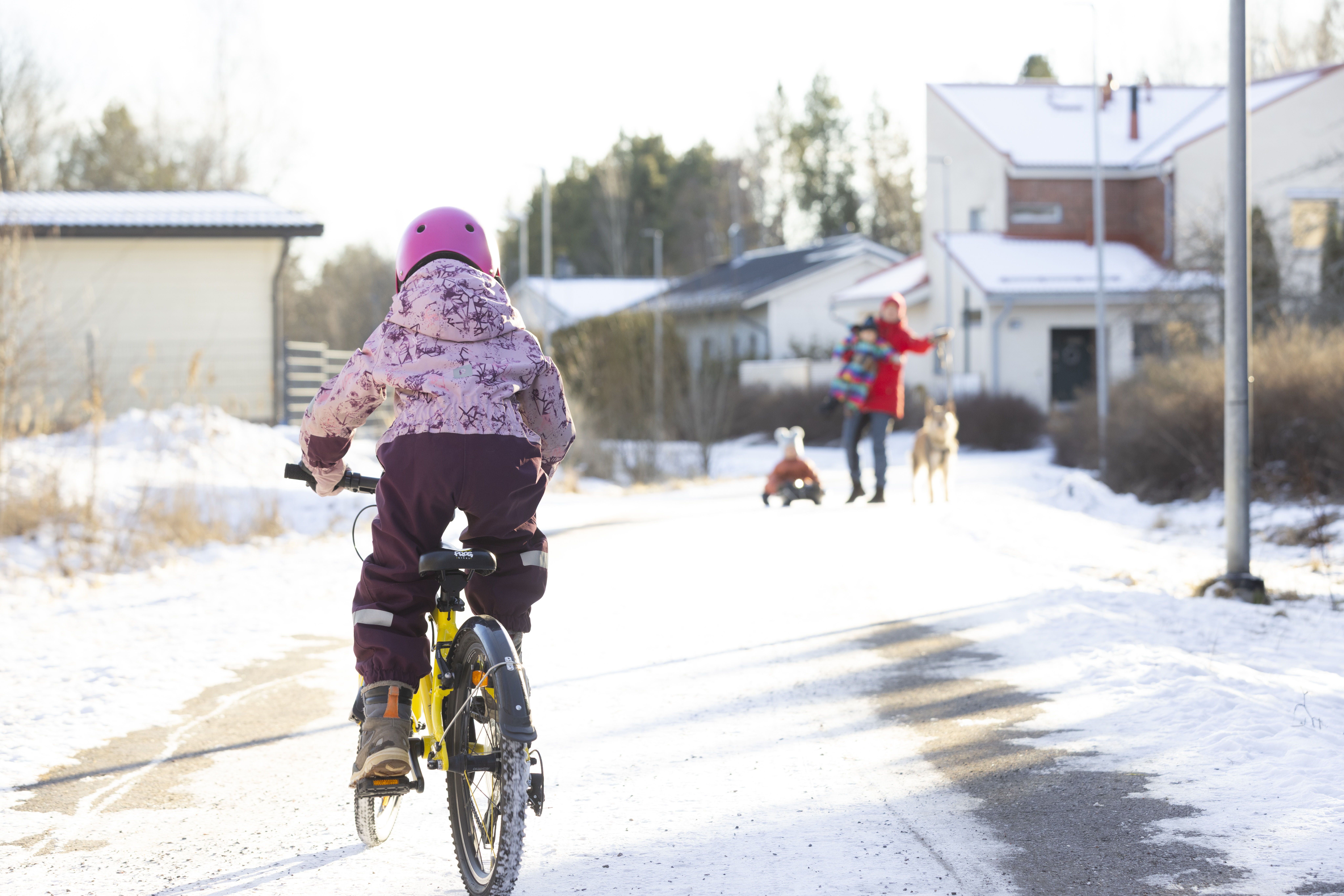 A child cycling in the winter to her mother.