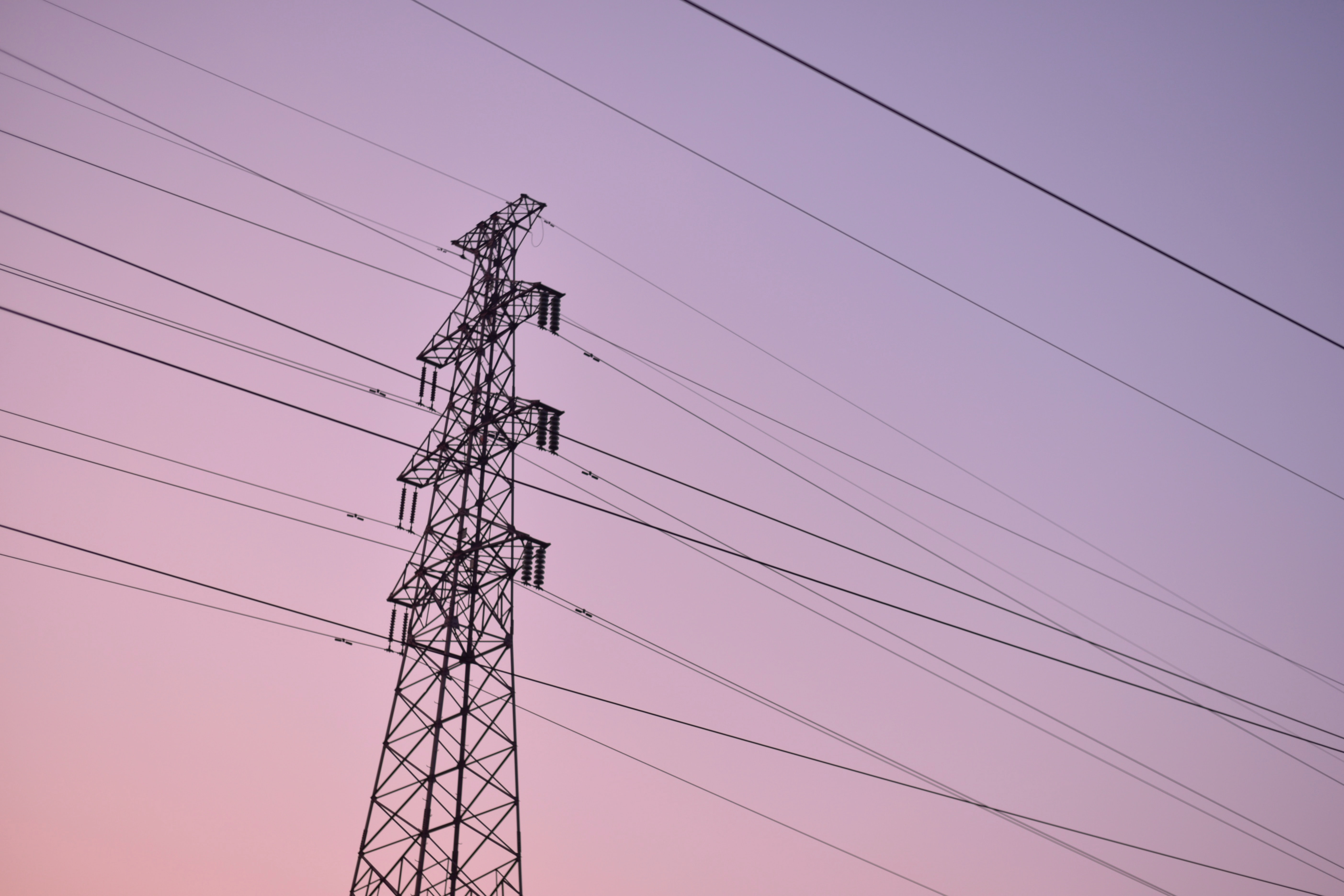 The electrical transmission tower with a purple sunset sky on the background.